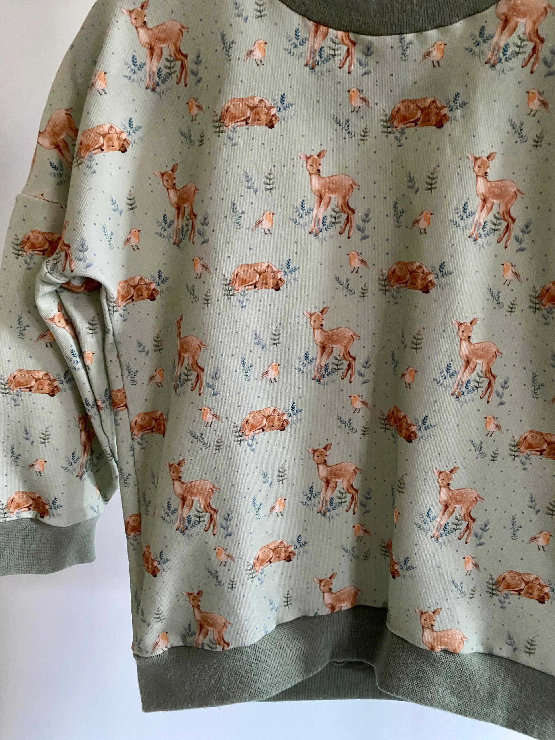 Genähter Pullover mit Reh und Vogel Motiv Detailansicht.