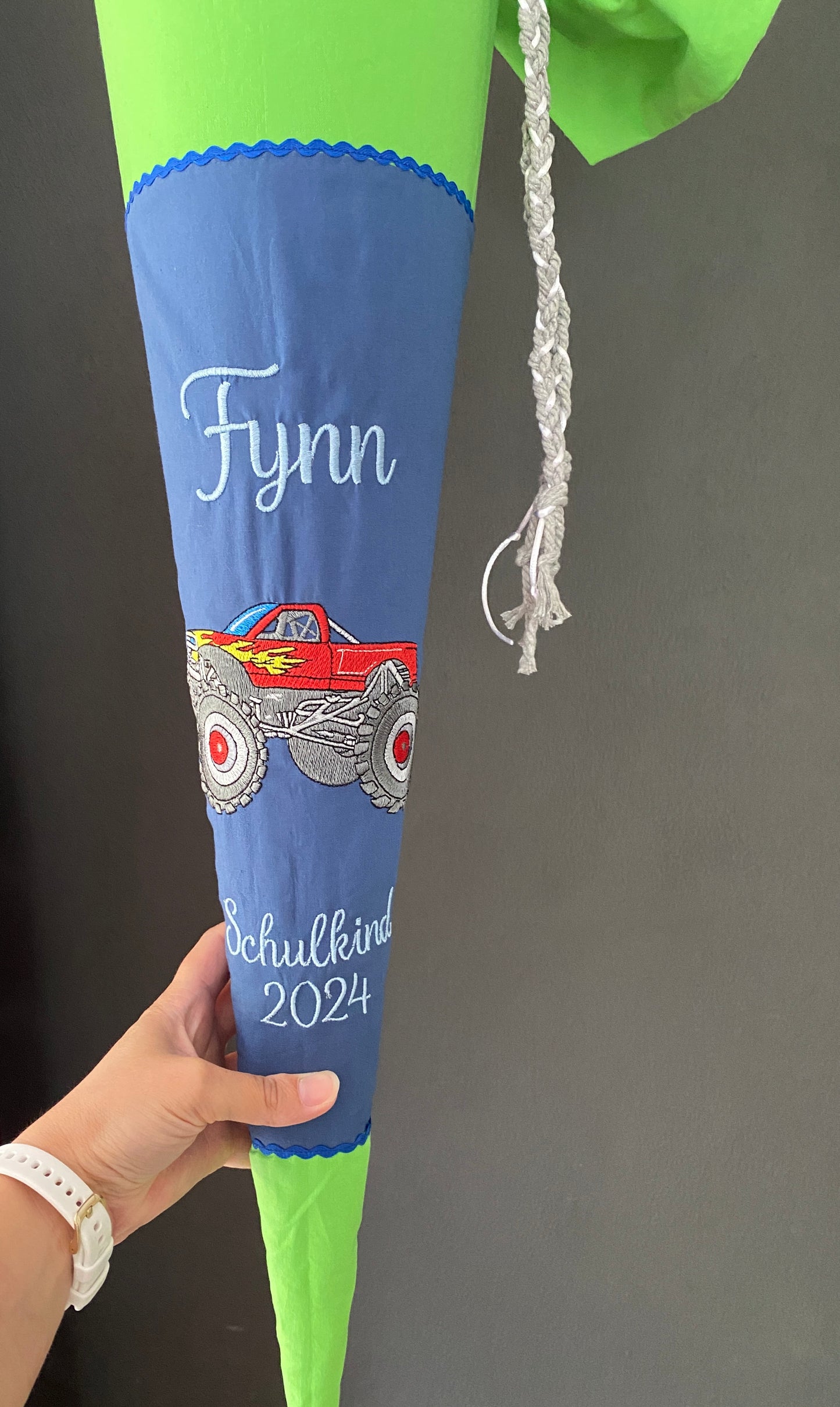 Schultüte Monstertruck in der Hand.
